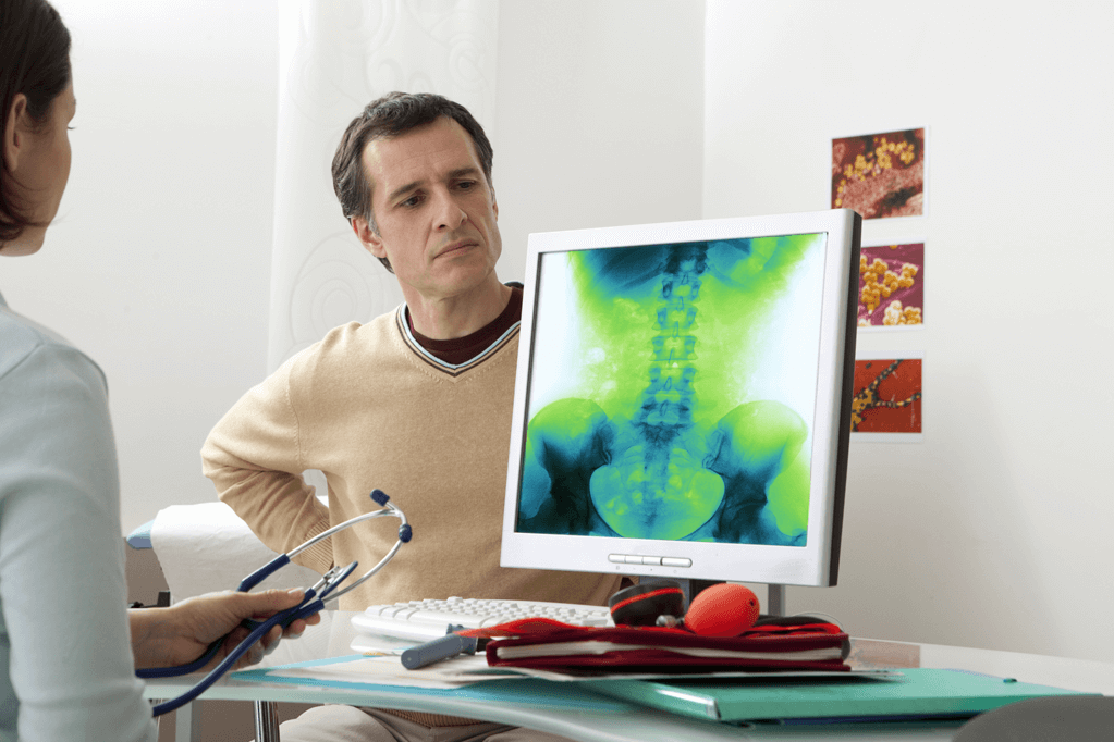 Man sitting in a doctors office with Ankylosing Spondylitis going through diagnosis with a Rheumatologist