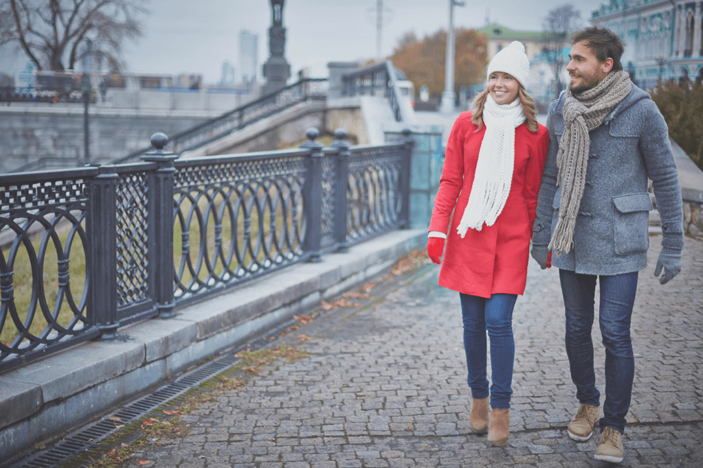 Couple walking while holding hands down a street in the winter