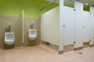 Public bathroom with green walls two stalls and two urninals