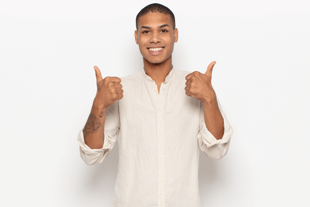Young Black Man against a white background giving a thumbs up with Managed Crohn's Disease
